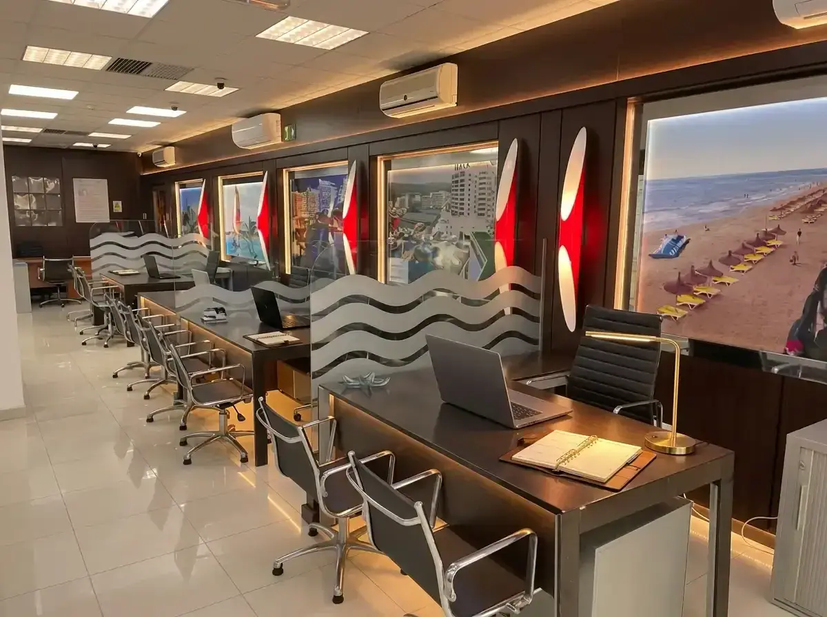 Service desks at the Príncipe de Vergara office, with beach photo panels on the wall