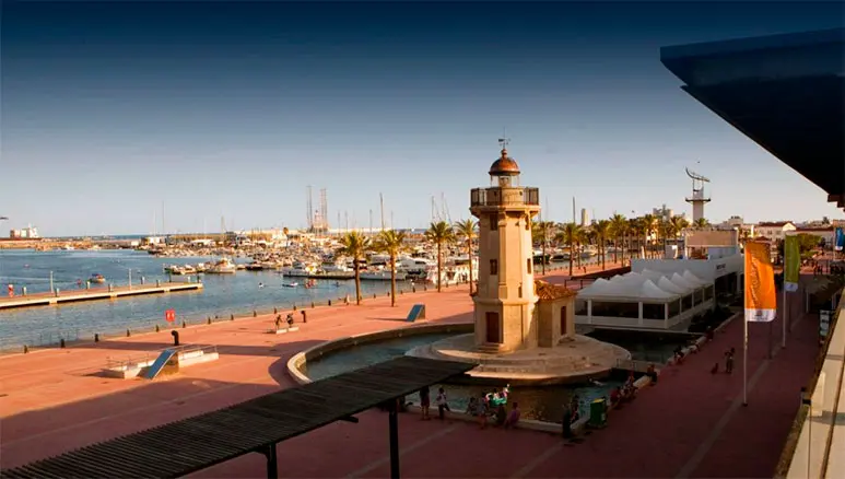 Vista del Casino Puerto Grao de Castellón con el puerto, un faro y áreas de recreo alrededor