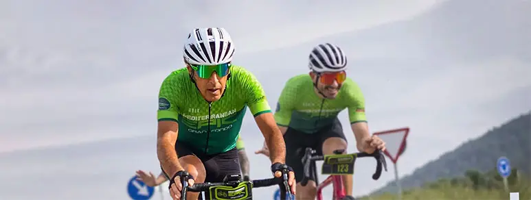 Dos ciclistas en plena carrera del Epic Gran Fondo, vistiendo maillots verdes.