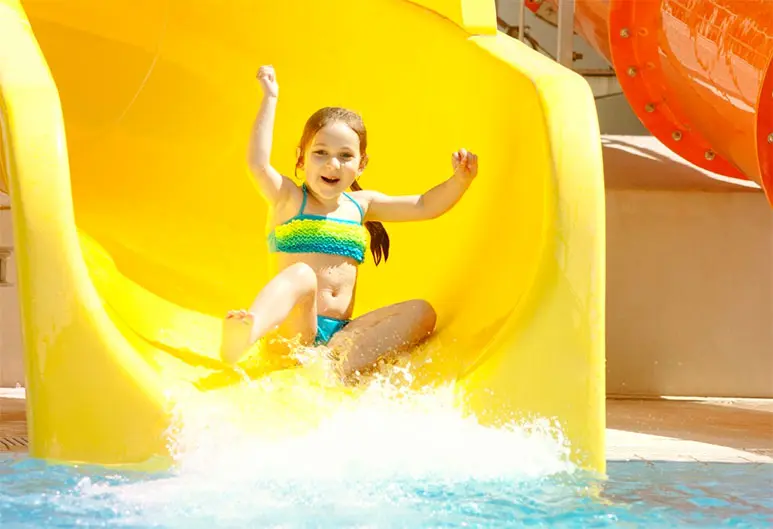 Момиченце на жълта пързалка в аквапарк Magic Splash Adventure