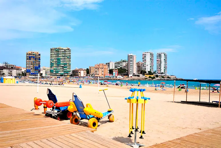Vista de la Playa de la Concha en verano con mobiliario de playa y bañistas disfrutando del mar