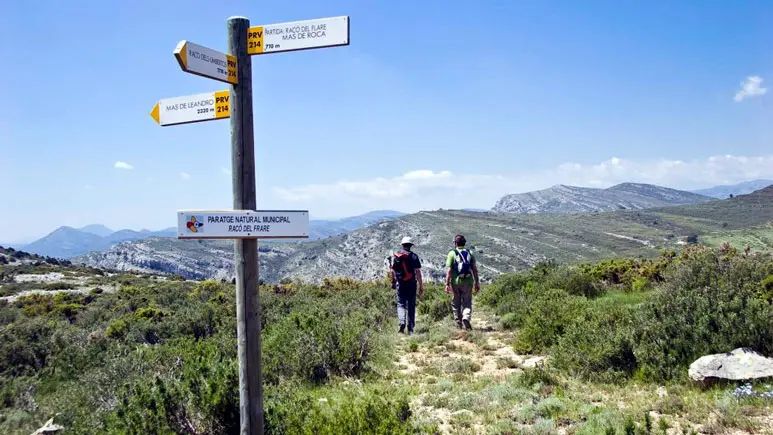 Wandelaars die bergpaden in San Mateu bewandelen, met wegwijzers